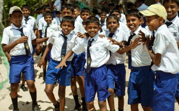 School children dressed in uniform have fun and play in the schoolyard. Wadduwa, Sri-Lanka.